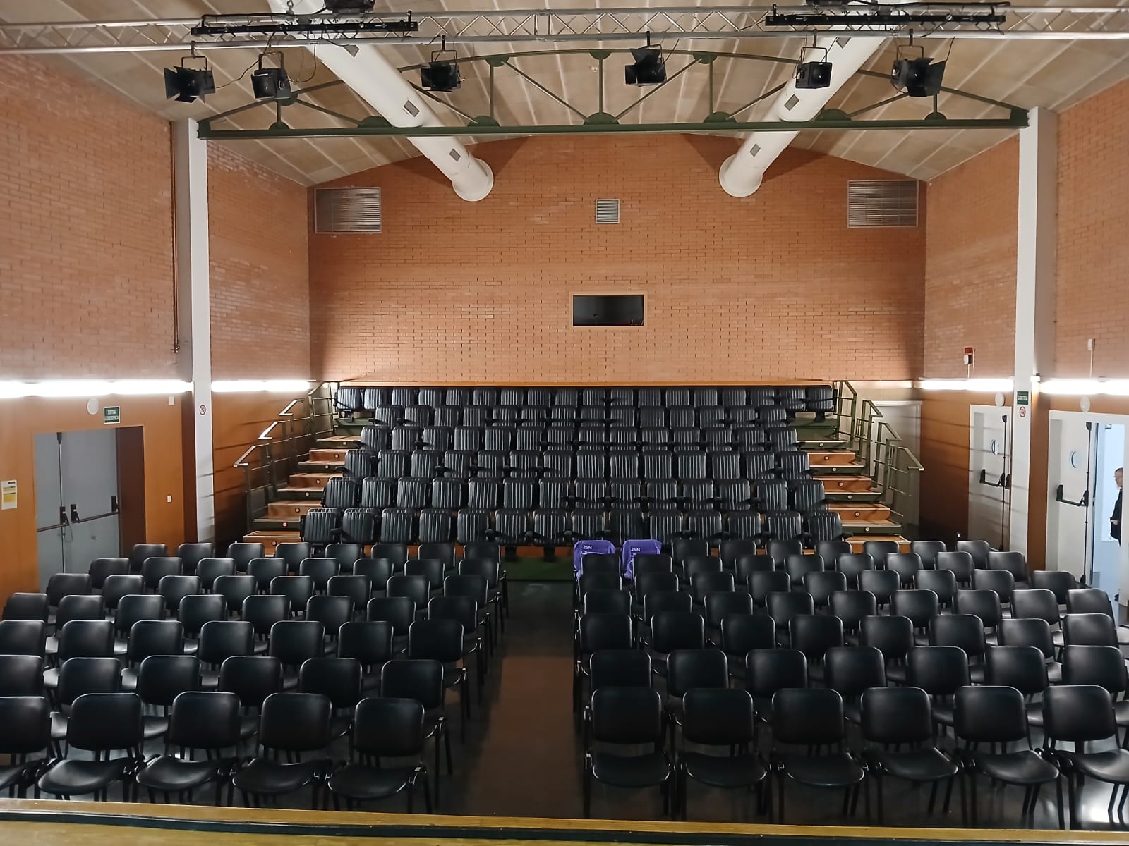 Fotografia de la sala d'actes centre cívic Can Rull, amb dues cadires liles buides